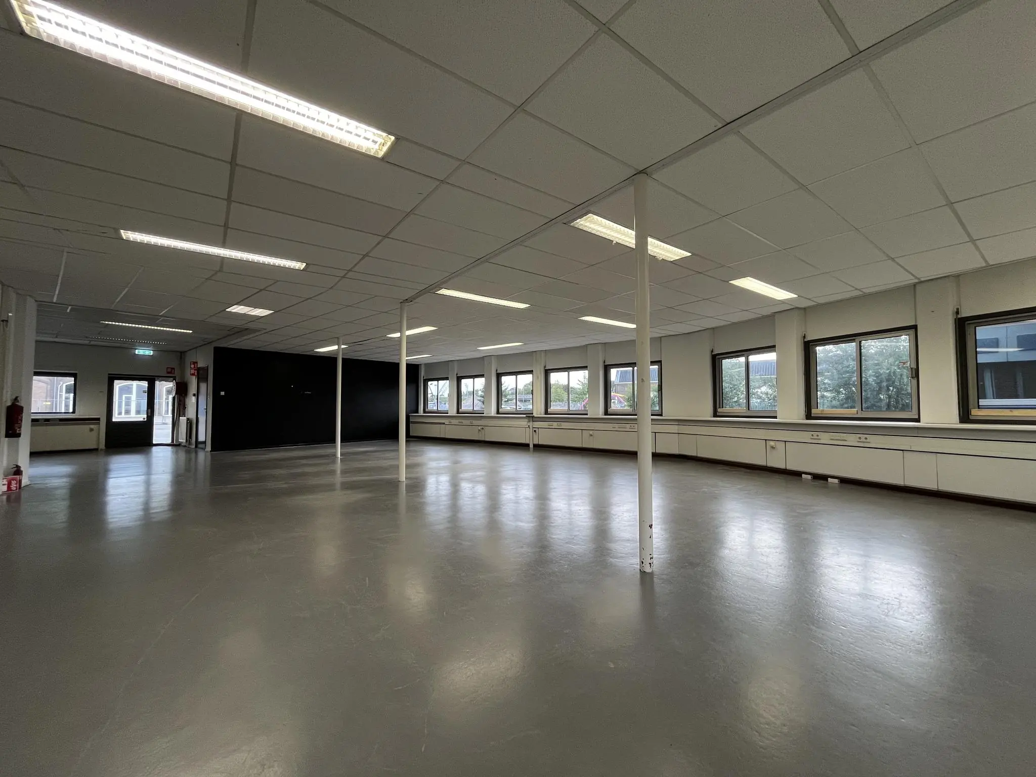 Ruime, lege kantoorruimte aan de 2e Daalsedijk met ramen langs de zijmuur en een gladde grijze vloer.